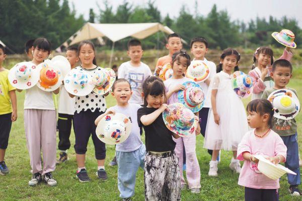 六一 5月27日，中鐵二局電務公司工會聯合成都溫江燈塔營地組織40余組員工家庭共同開展“六一”親子活動，將關心關愛送到廣大員工及子女身邊。圖為孩子們參加草帽涂鴉活動。張承林 攝